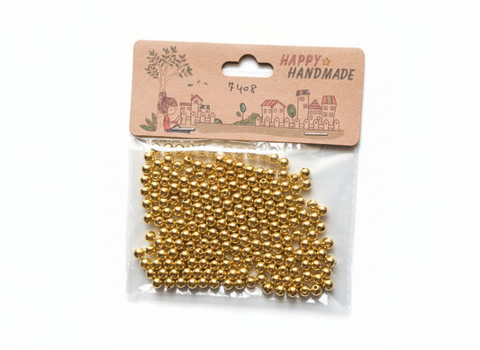 Gold bead string in clear packaging on a cardboard holder with decorative text.