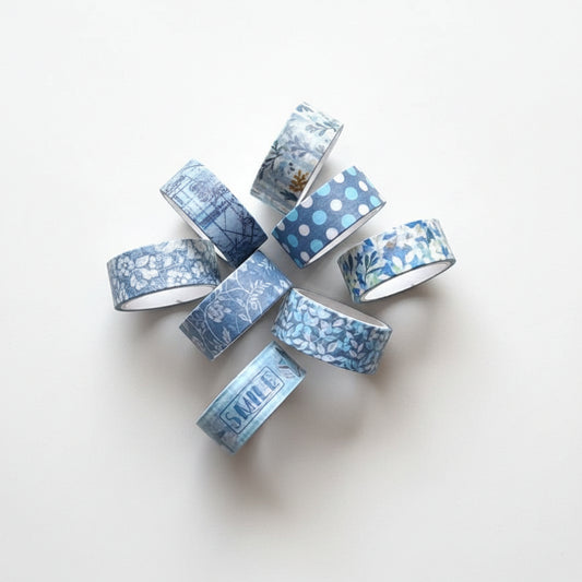 Set of blue washi tape rolls on a white fabric background